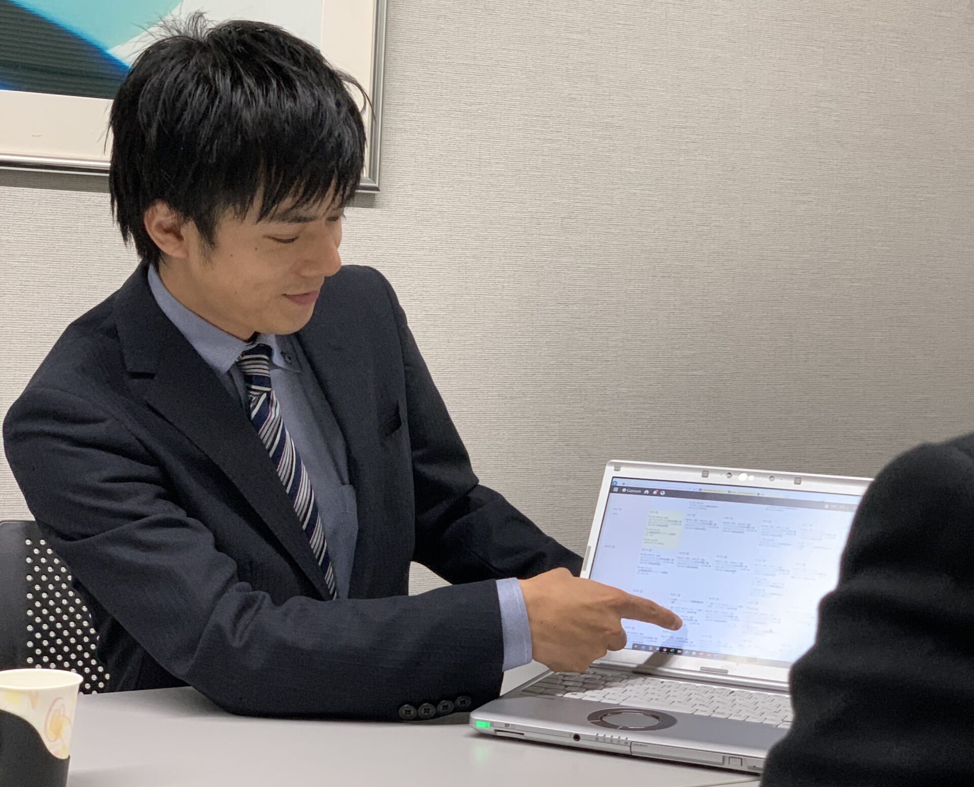 映像システムについてお客様と商談する様子